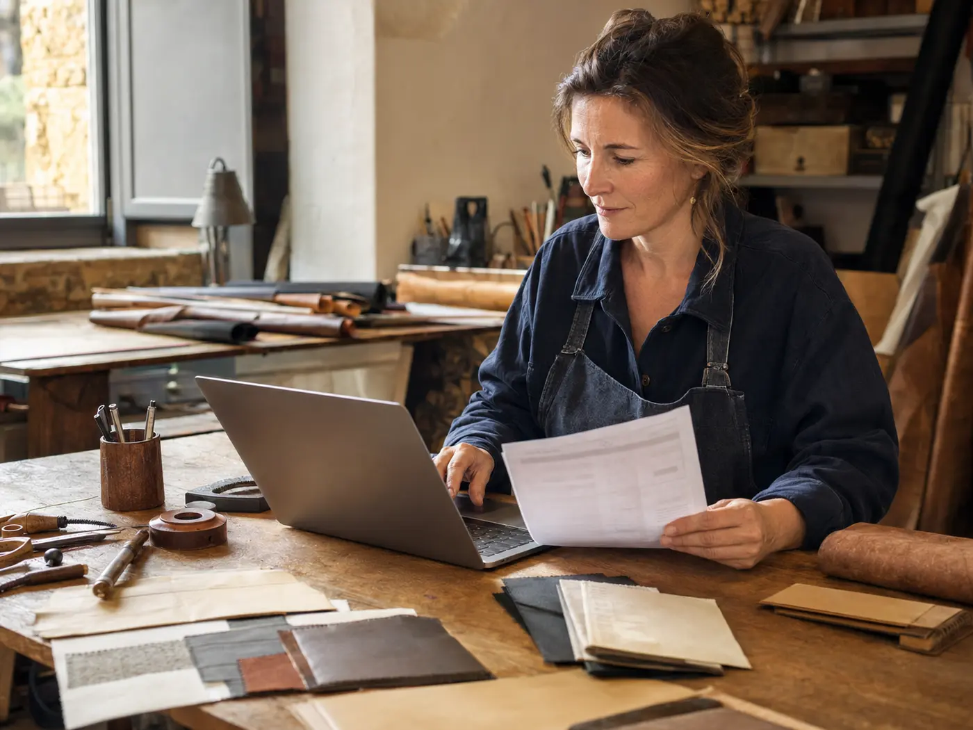 Une artisane vérifie le règlement d’une facture dans son atelier